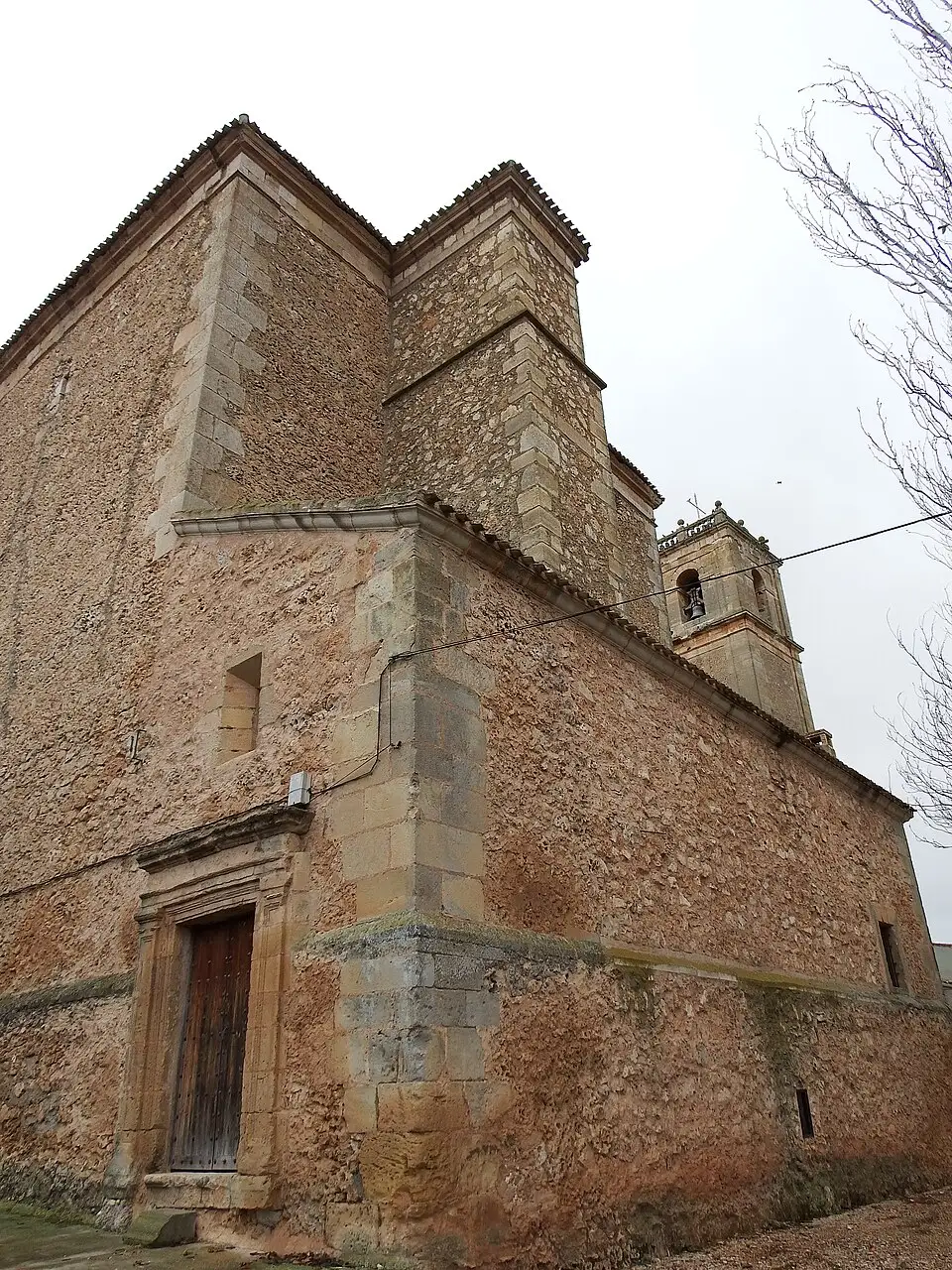 Vista lateral de la iglesia y su torre campanario